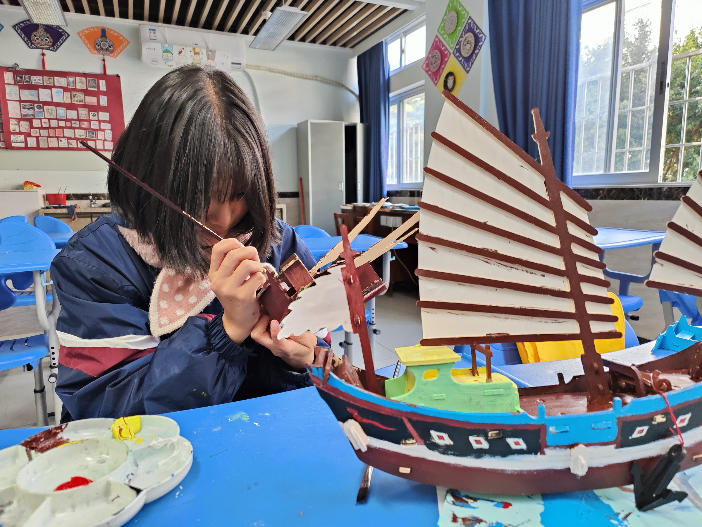学生正在为福船模型彩绘